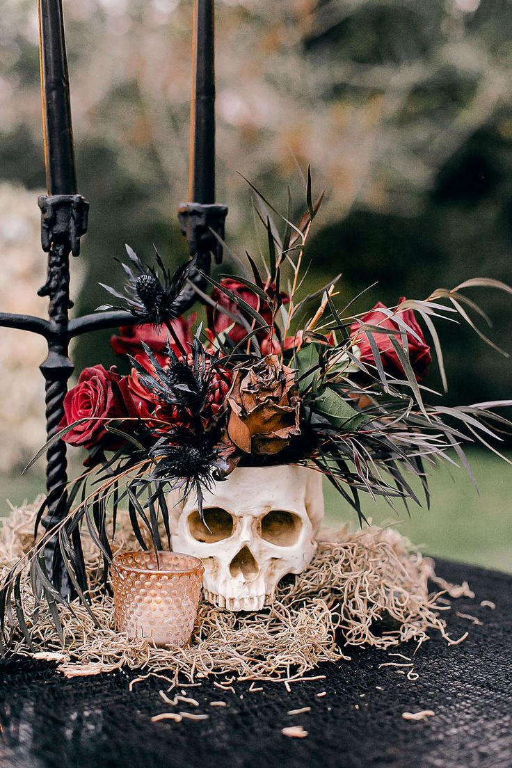 there is a skull with flowers in it on the table