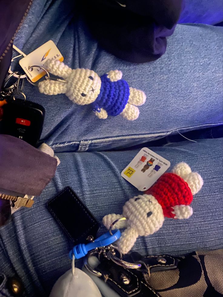 two stuffed animals sitting on the back of a person's jeans with cell phones attached to them