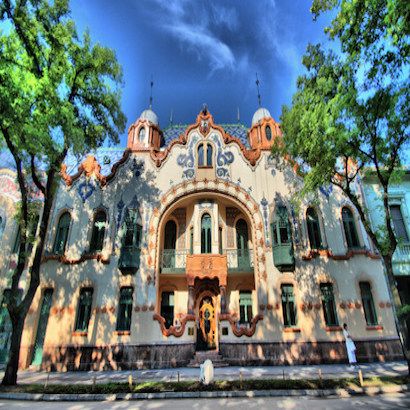 an old building with many windows and trees