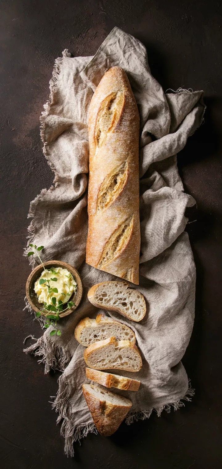 a loaf of bread sitting on top of a table next to a bowl of food