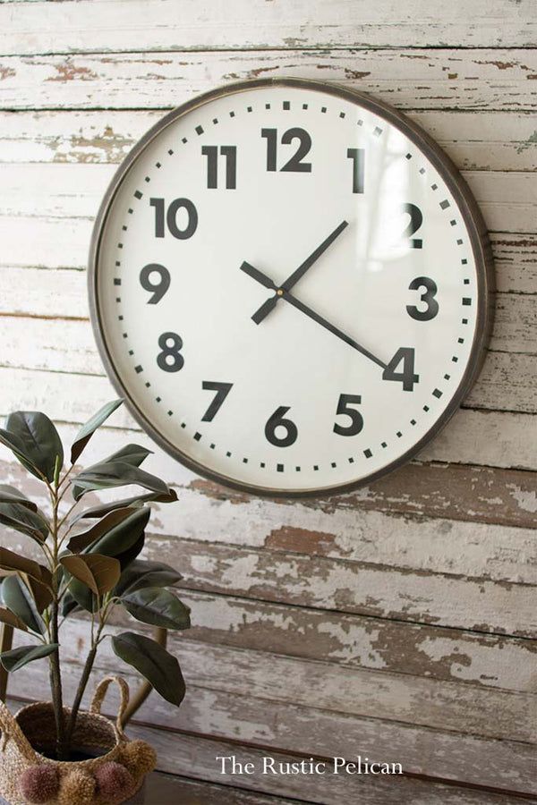 a clock hanging on the wall next to a potted plant