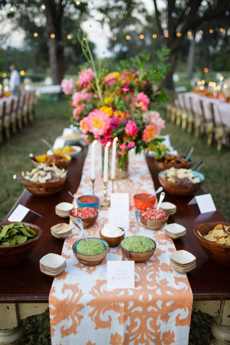 a long table covered in bowls and plates filled with food