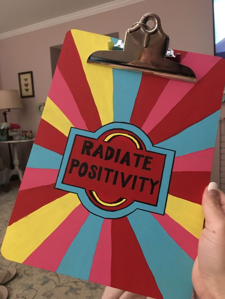 a hand holding a clipboard with the word radiate positivity on it