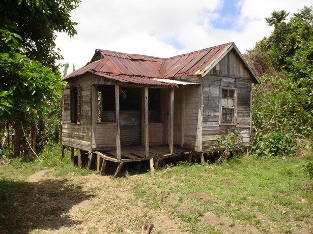 an old run down wooden house sitting in the grass