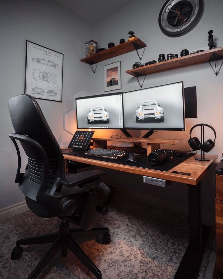 two computer monitors sitting on top of a wooden desk