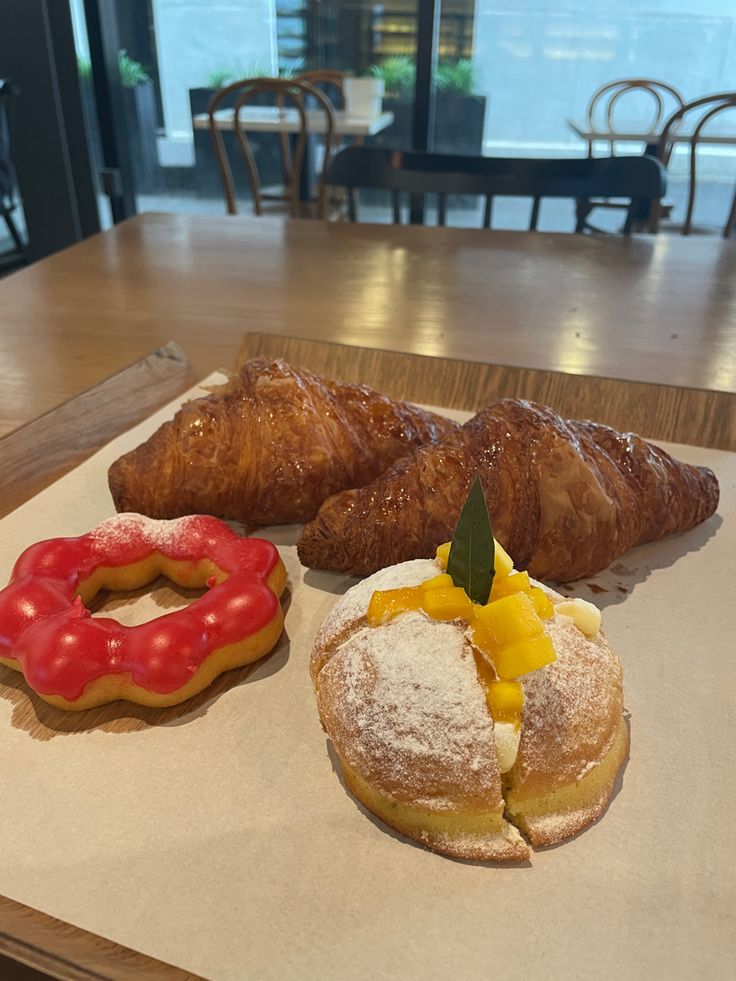 three pastries and two donuts on a table