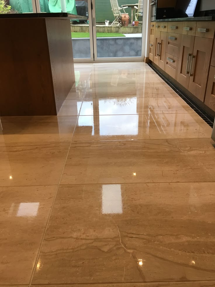 a marble floor in a kitchen with stainless steel appliances