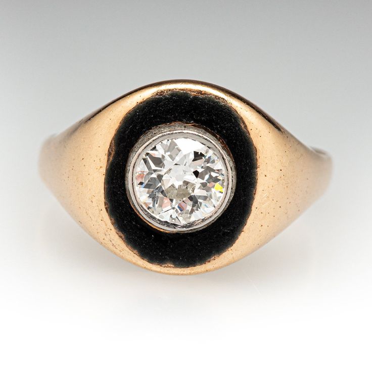 This storied circa 1920s 14K yellow gold ring is centered with one (1) old European cut diamond set into a platinum bezel that is bordered black enamel. The ring measures 10.4mm at the top, rises 3.3mm above the finger, tapering to 1.9mm wide and 0.7mm thick at the base of the shank. It currently fits a size 4.25. Please note that there is some wear on the enamel, and the ring is a bit oblong from a previous resizing. Vintage Diamond Enamel Ring, Round Black Enamel Diamond Ring For Anniversary, Black Enamel Diamond Anniversary Ring, Diamond Enamel Ring With Black Enamel, Vintage Round Diamond Enamel Ring, Vintage 14k Gold Diamond Ring With Bezel Setting, Classic White Gold Enamel Ring, Antique Signet Ring With Single Diamond, Vintage Diamond Enamel Round Ring