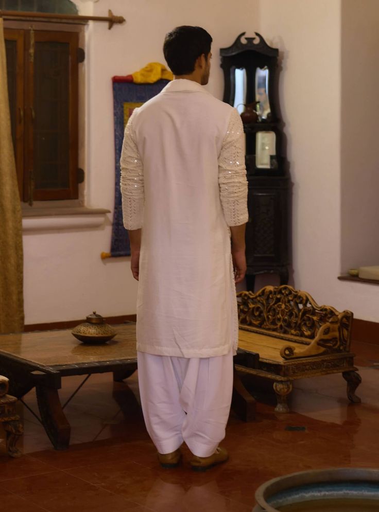 The umaid kurta in ivory is a sophisticated choice for Indian grooms, perfect for haldi, mehndi, or sangeet ceremonies. Crafted from a blend of viscose cotton silk and georgette, this kurta offers a soft, breathable feel that’s ideal for festive occasions. This kurta comes with a matching ivory salwar, creating a seamless and cohesive ensemble. Whether you're attending a traditional ceremony or a contemporary event, the umaid kurta is a versatile and elegant choice. Traditional Slub Silk Sherwani For Transitional Season, Unstitched Slub Silk Sherwani For Transitional Seasons, Transitional Unstitched Slub Silk Sherwani, Festive Transitional Slub Silk Sherwani, Slub Silk Kurta With Traditional Drape For Wedding, Transitional Festive Sherwani In Slub Silk, Transitional Festive Slub Silk Sherwani, Diwali Straight Kurta Sherwani In Slub Silk, Wedding Cotton Silk Kurta With Gota Work