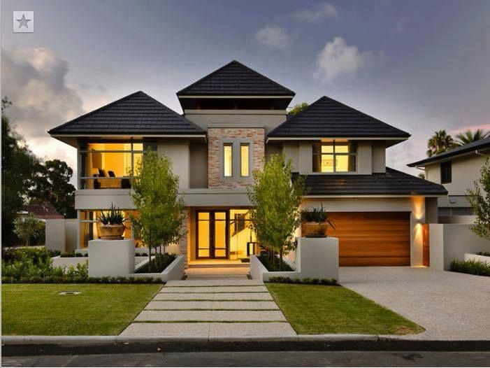 a large house with two story windows and lots of greenery in the front yard