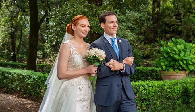 a bride and groom standing in front of some bushes