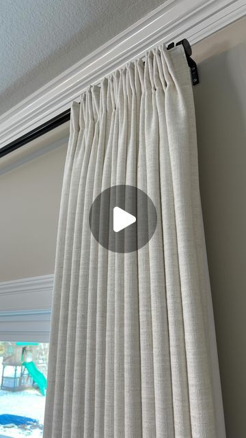 a white curtain hanging on the side of a window