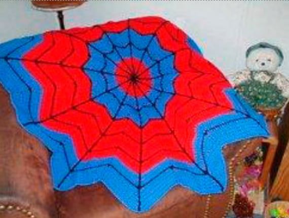 a crocheted spider web blanket sitting on top of a brown chair