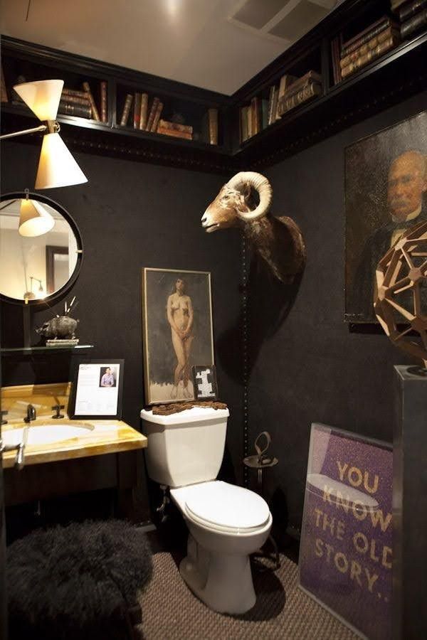 the bathroom is decorated in black and white with an animal's head on the wall