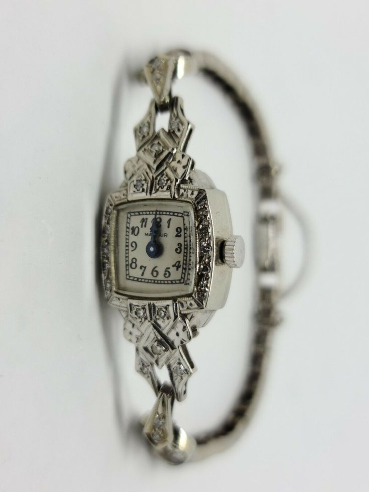 14K White Gold Vintage MAYFAIR Diamond Wrist Watch 6.5" inches with a 3" Safety Chain Beautiful Vintage Look with White Dial and Black Arabic Numbers and Blue Steel Hands. 65 Round diamonds for a total of 0.30 carats and a total weight of 12.84 Grams Includes GAL Appraisal MSRP $3,200 Condition is "Pre-owned" and in working condition with some signs of wear and stretch Shipped Free with USPS Priority Mail Antique Platinum Evening Watches, Luxury Collectible Quartz Jewelry And Watches, Art Deco Platinum Evening Watches, Platinum Art Deco Evening Watches, Elegant Collectible Watch With Rectangular Dial, Classic Engraved Jewelry And Watches For Formal Occasions, Timeless Engraved Formal Watches, Timeless Engraved Watches For Formal Occasions, Timeless Engraved Round Dial Jewelry And Watches