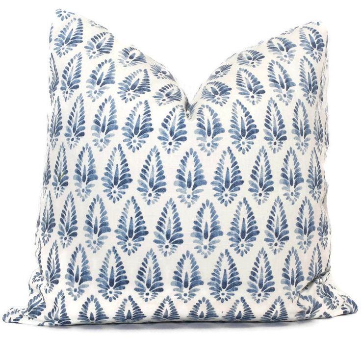 a blue and white pillow with leaves on it