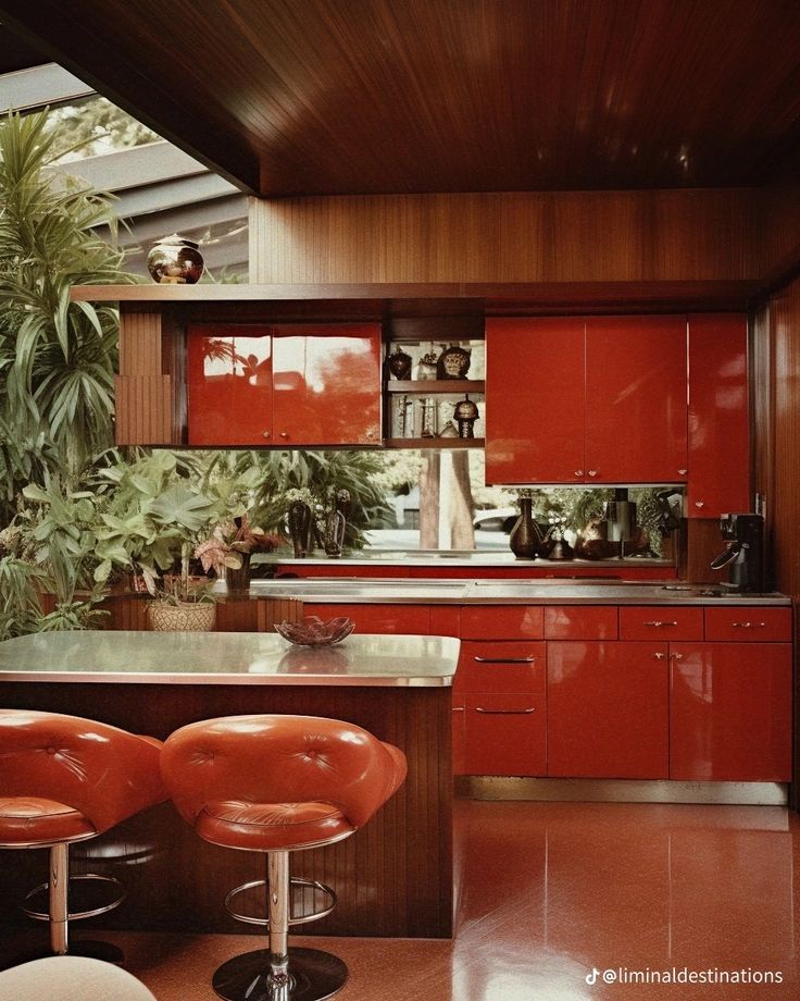 an image of a kitchen setting with red cabinets and stools on the counter top