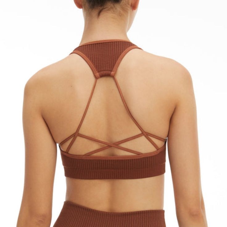 New Year, New You. Meet The Seamless Strappy Back Rib Bra. Innovative Workout Fabrication For The Smoothest Shape And Fit Yet. Pair It With The Seamless Ribbed Legging For The Full Look. Square Neckline Strap Back Ribbed Textured Seamless Construction Medium Support Padded Brown Color 93% Nylon 7% Elastane Care: Machine Wash Cold Gentle Cycle. Tumble Dry Low S/M Order Size 1/2 Brown Stretch Crop Top With Built-in Bra, Brown Seamless Activewear, Fitted Seamless Brown Sports Bra, Fitted Brown Seamless Sports Bra, Brown Stretch Seamless Tank Top, Strappy Seamless Yoga Crop Top, Seamless Strappy Yoga Crop Top, Sunset Swim, Black Cropped Sweater