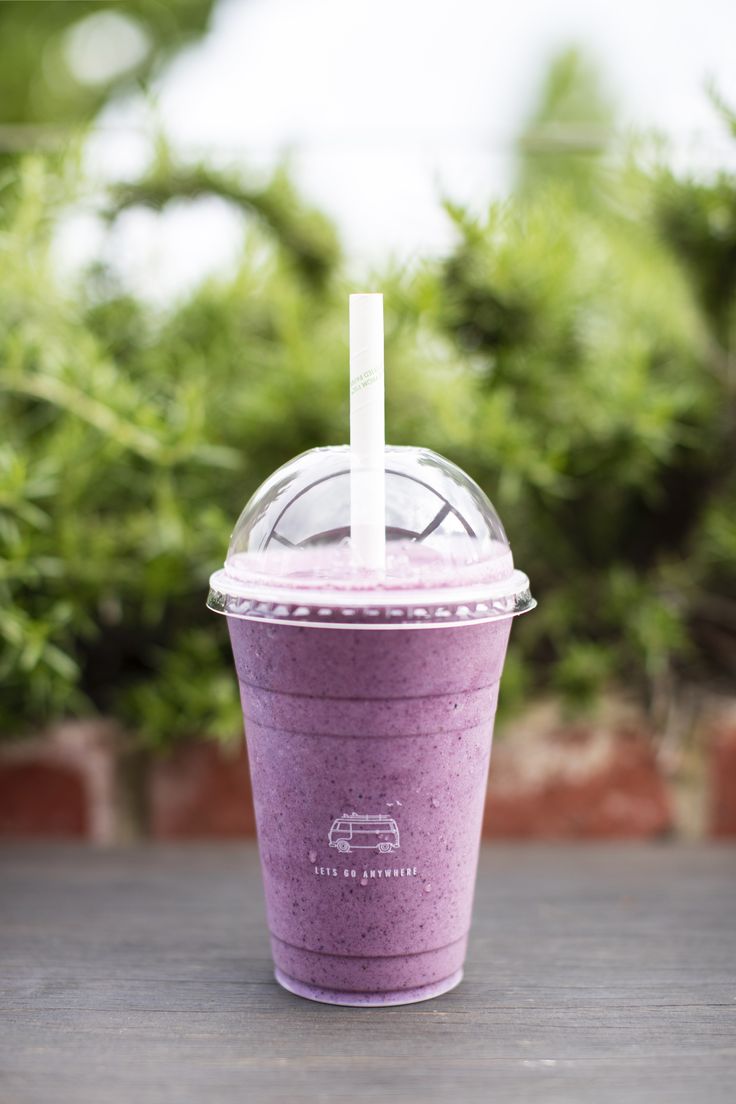 a purple smoothie in a plastic cup with a straw sticking out of the top