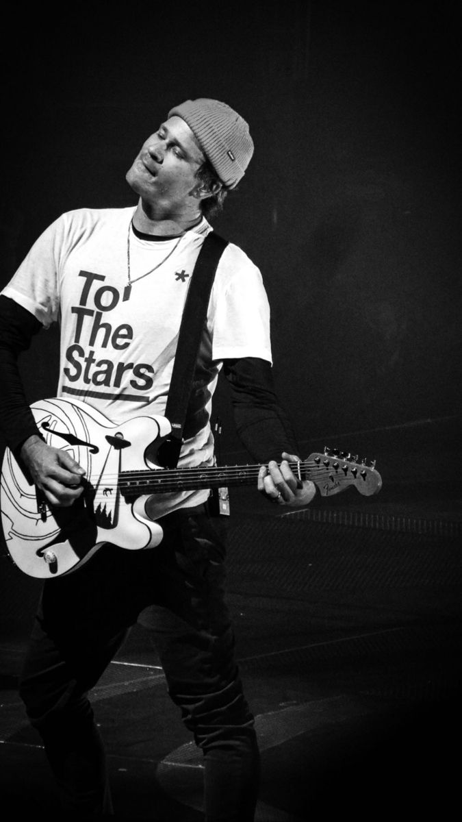 black and white photograph of a man playing an electric guitar with the words to the stars on his t - shirt