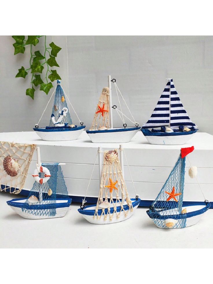 four small sail boats are sitting on a shelf