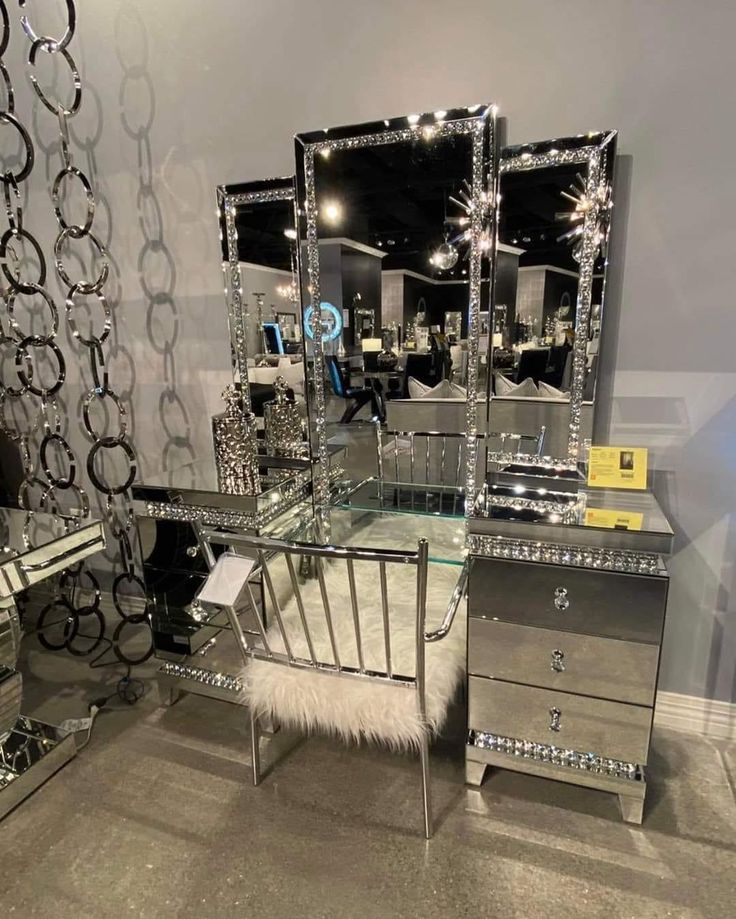 a mirrored vanity table with three mirrors on it and a fur rug in front of it