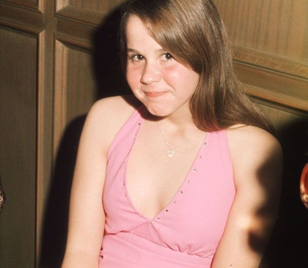 a woman in a pink dress sitting at a table