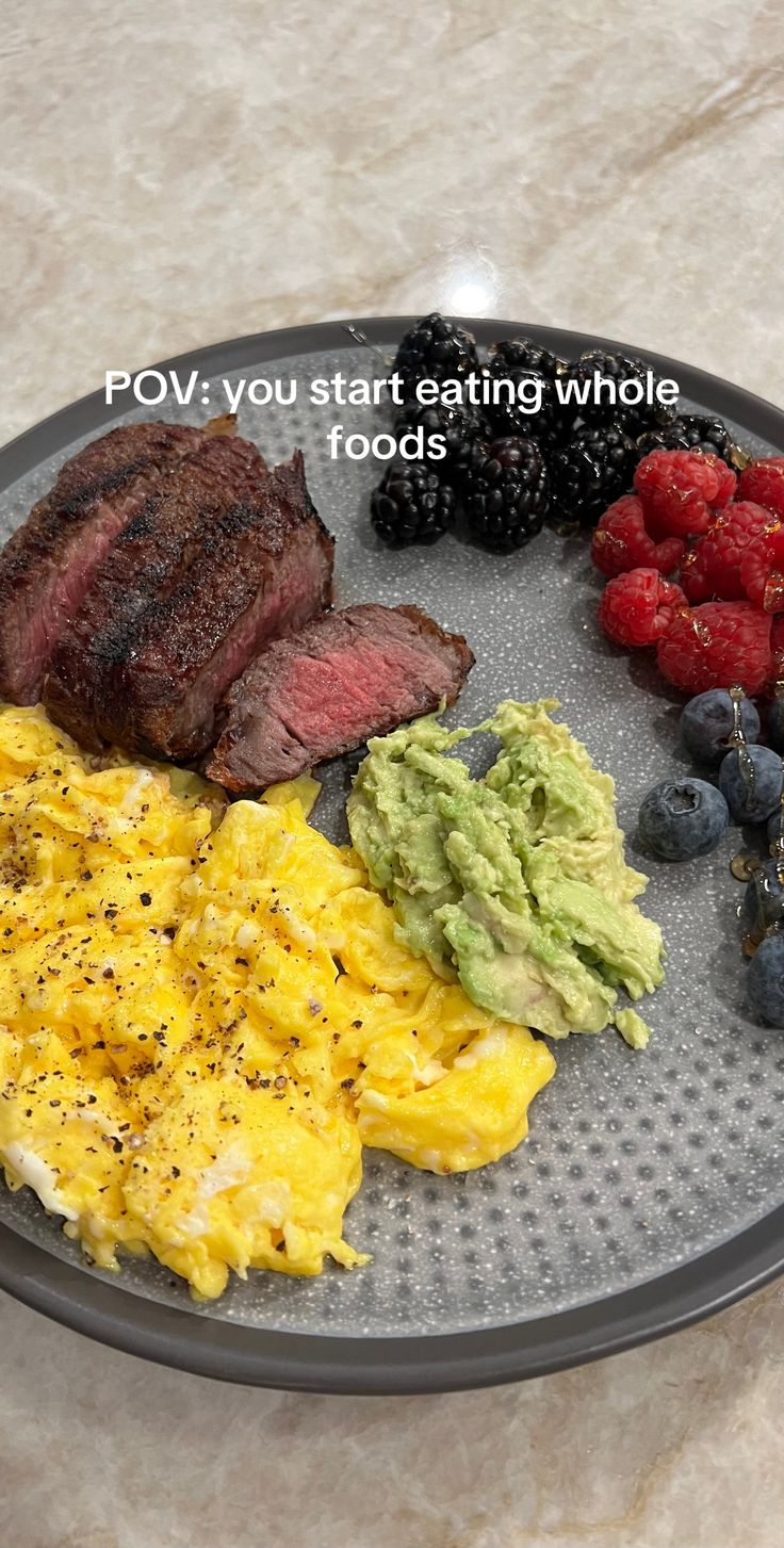 a plate with eggs, meat and fruit on it that says pov you start eating whole foods