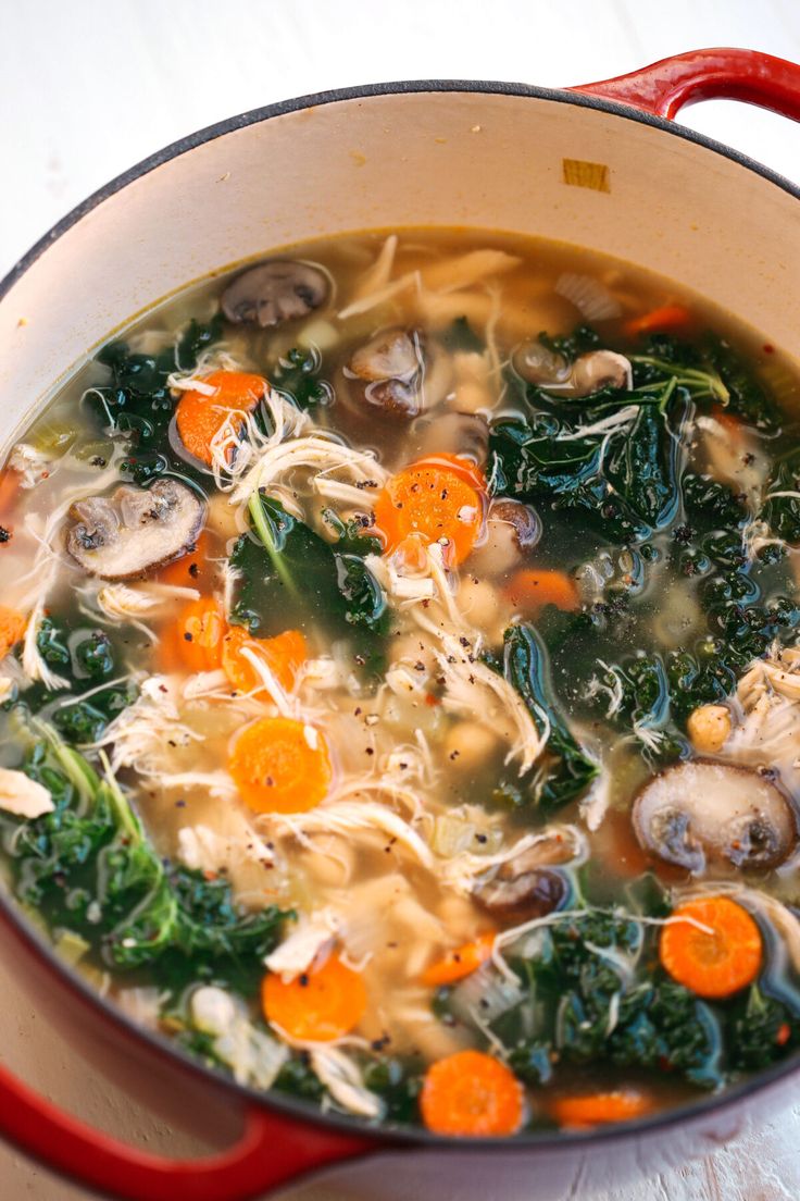 a red pot filled with soup on top of a table