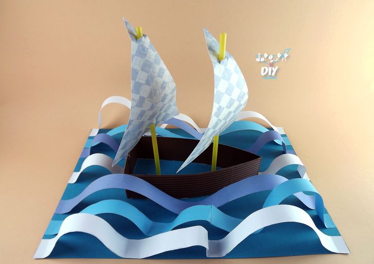 a paper boat floating on top of blue waves