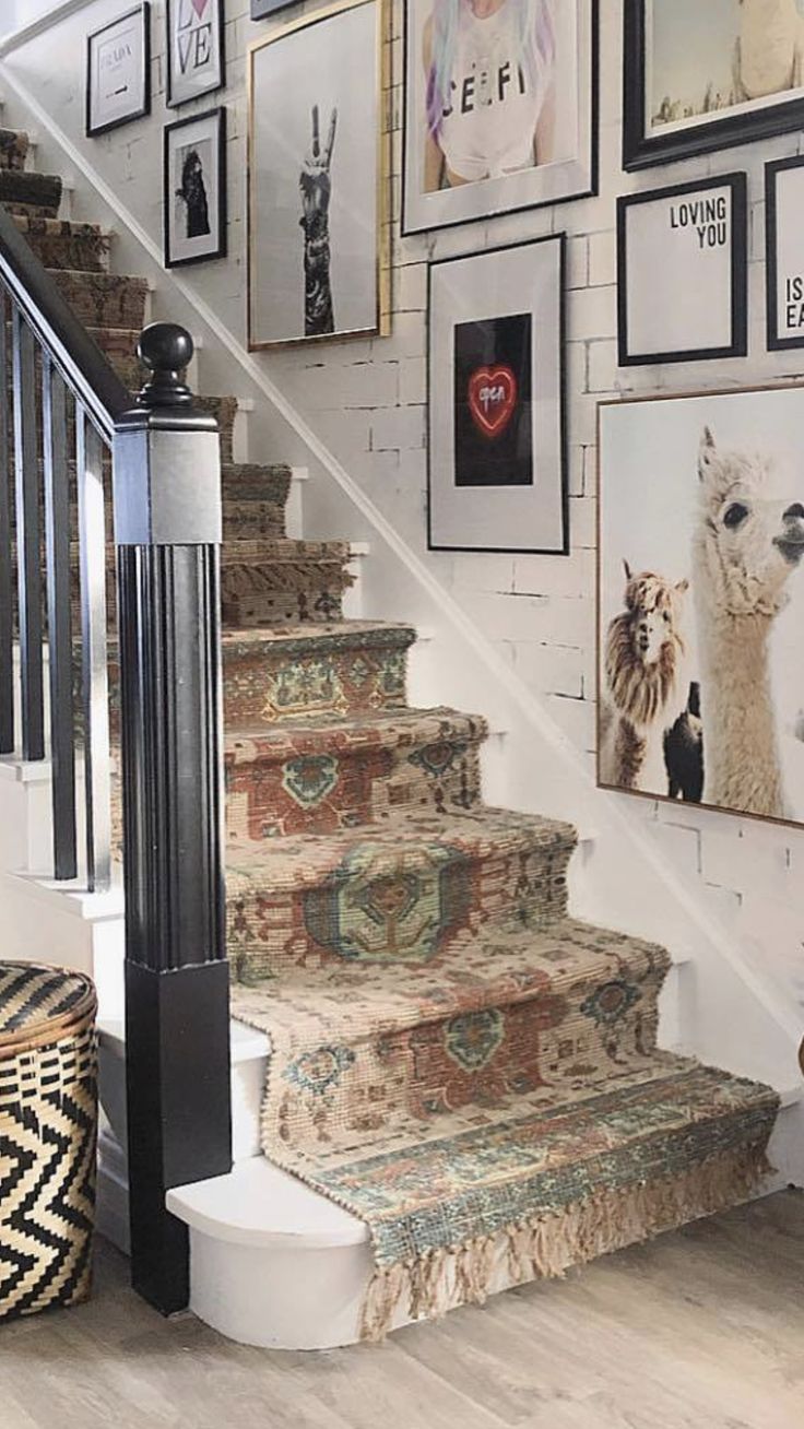 a staircase with pictures on the wall and carpeted steps leading up to the second floor