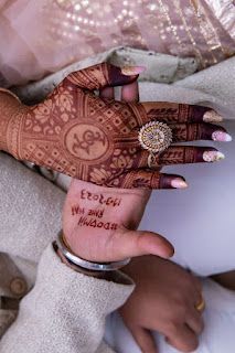 a woman's hands with henna tattoos and writing on her hand that says enjoy and welcome