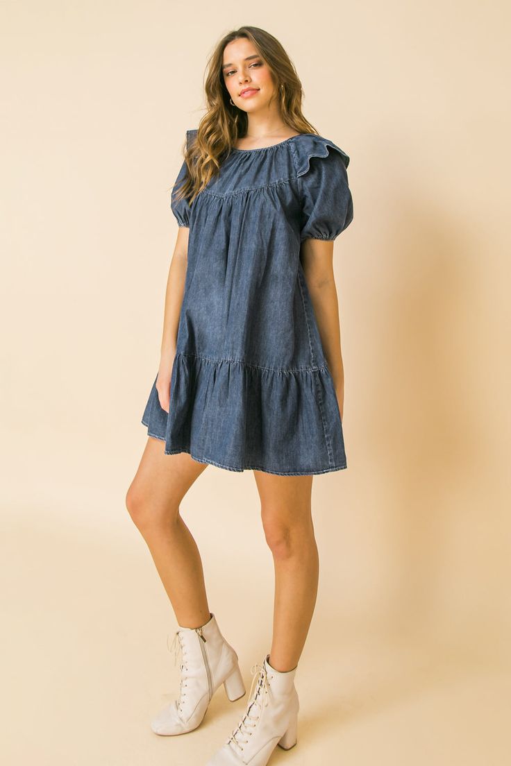 A lightweight denim mini dress featuring round neckline, ruffle at shoulder, puff sleeve, ruffled hemline and keyhole button closure Details Self: 100% Cotton Size & Fit - Model is 5`8" And Wearing Size Small - Measurements Taken From Size Small - Approx. Length: 30.5" Blue Casual Mini Hem Dress, Cotton Ruffles Mini Dress, Cotton Mini Hem Dress With Ruffles, Cotton Ruffle Dress With Mini Hem, Dark Wash Denim Mini Dress For Day Out, Cotton Mini Hem Dress For Spring, Cotton Mini Dress With Ruffles, Dark Wash Knee-length Dress For Casual Wear, Trendy Medium Wash Short Sleeve Mini Dress