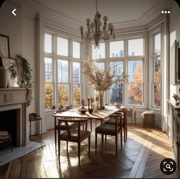 a dining room table and chairs in front of large windows