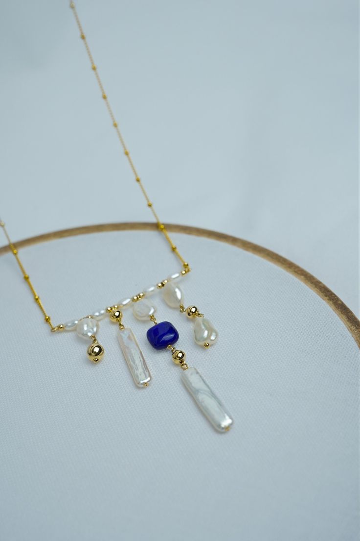 "Measurements: Keshi Pearl Size: 7mm,  Stick shape baroque pearl size: 22x6mm, Necklace length: 20\" Hand strung with stick shape baroque pearls and keshi pearl, highlighted by a cushion-shape lapis lazuli, marrying elegance to earthiness. Wear it as an accent, layer it and  showcase it against your beachwear or evening attire. Material: 14k Gold Filled 14k gold filled is a strictly regulated process that involves pressure bonding multiple layers of solid 14k gold with extreme heat over a core of high quality jeweler's brass resulting in a durable, quality real gold product. Freshwater Pearl  Cultured freshwater pearls are farmed and created using freshwater mussels. We carefully select for our piece with great luster and quality. Every item is handcrafted. Shipping will be available withi Handmade Blue Baroque Pearl Necklaces, Blue Baroque Pearl Necklace With Pendant, Handmade Blue Baroque Pearl Necklace, Blue Baroque Pearl Necklace With Pearl Charm, Blue Baroque Pearl Jewelry With Pearl Drop, Blue Baroque Pearl Necklace As A Gift, Blue Baroque Pearl Jewelry With Pearl Pendant, Blue Baroque Pearl Jewelry With Pendant, Blue Baroque Pearl Pendant Jewelry