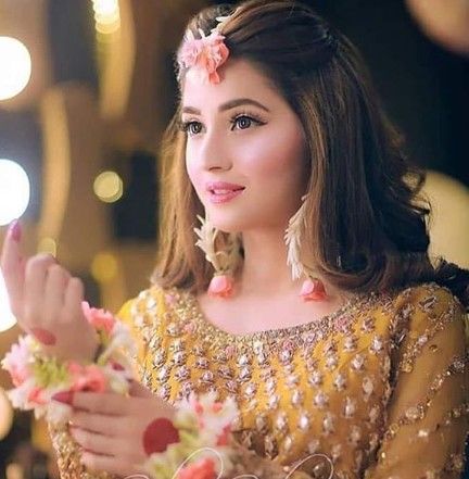 a woman in a yellow dress holding flowers