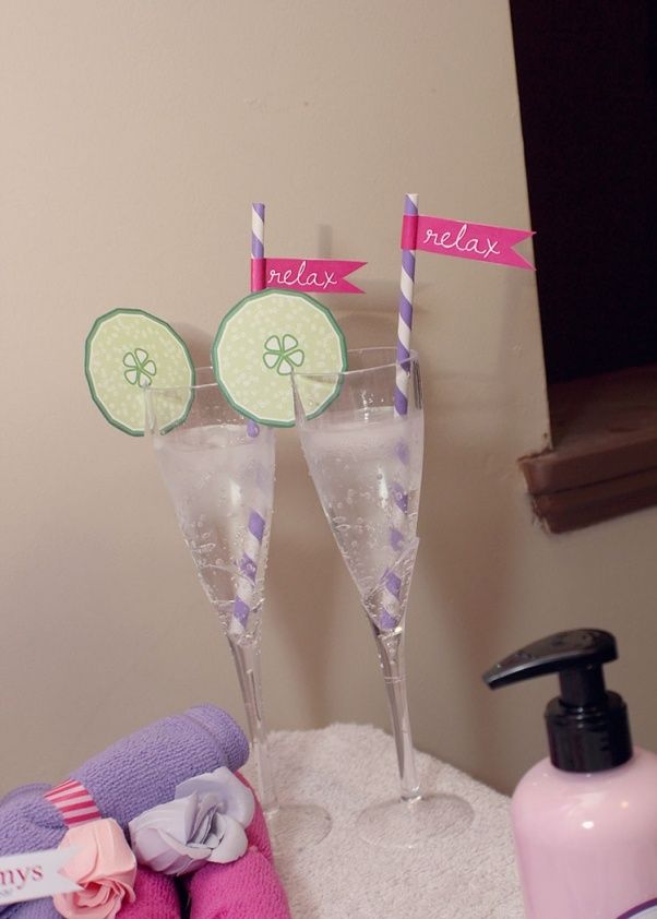 two champagne flutes with lime slices on them sitting next to some towels and soaps