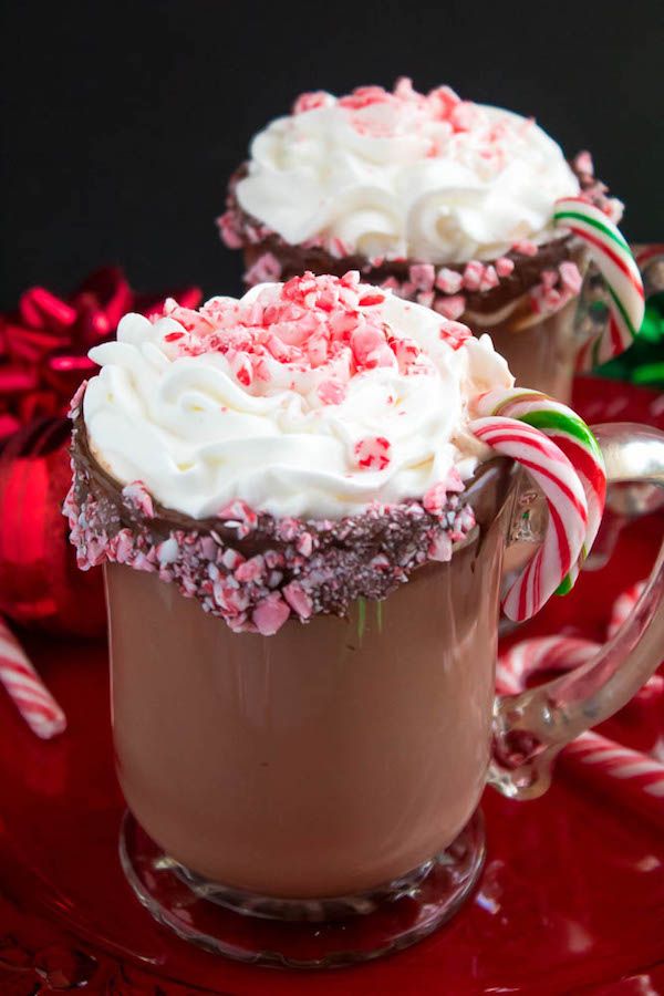 two mugs filled with hot chocolate and candy canes