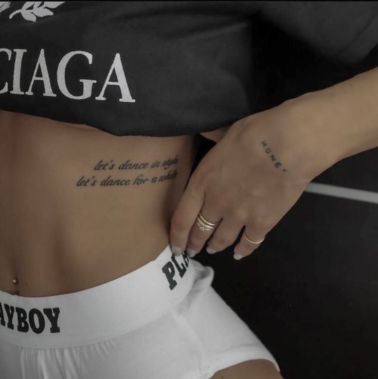 a close up of a person with tattoos on their stomach and the words ciaga written on her side