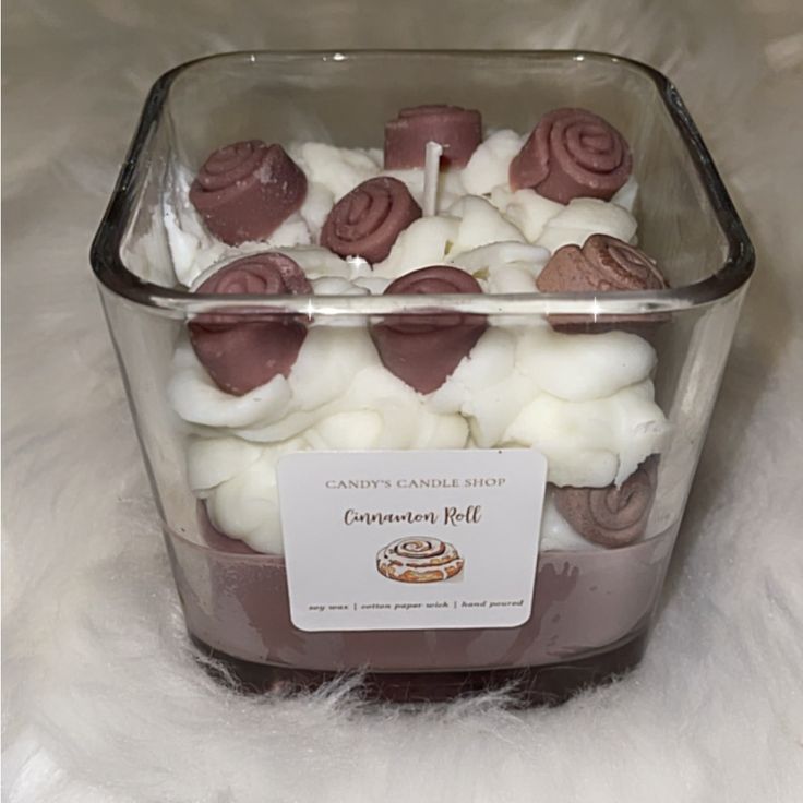 a container filled with marshmallows on top of a white fur covered floor