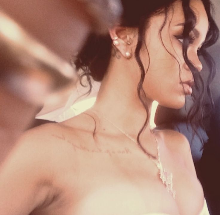 a close up of a person wearing a dress and necklace with hair blowing in the wind