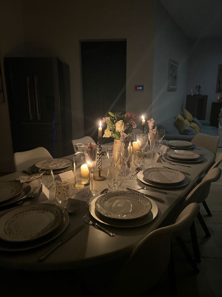 a table set for dinner with candles and plates