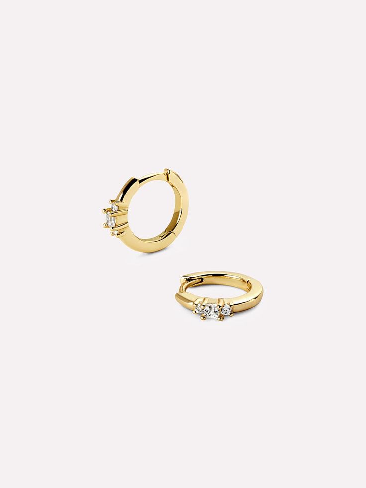 A modern twist on a classic style, these gold huggie hoops feature centered, channel-set cubic zirconia gemstones. Lightweight and dainty, these beautiful huggies are crafted in recycled Sterling Silver and dipped in 14K gold. These playful gold huggie hoops can be worn day and night with just about any outfit. • Sterling Silver huggies dipped in 14K gold • Lightweight, dainty & high-polish finish • Adorned with shimmering cubic zirconia gems Silver Huggies, Gold Huggies, Mary Jane Shoes Womens, Sneaker Dress Shoes, Huggie Earrings, Channel Set, Cold Weather Accessories, Everyday Earrings, Gold Hoops