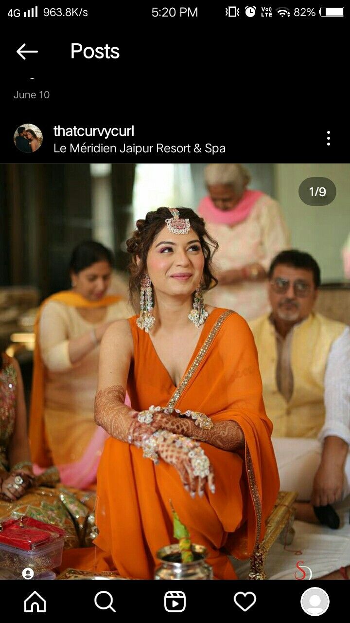 a woman in an orange sari sitting down