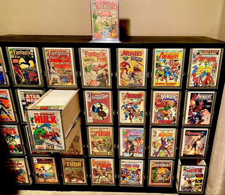 a display case filled with comic books on top of a carpeted floor next to a wall