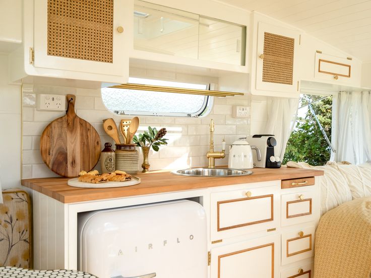 a kitchen with white cabinets and wooden counter tops