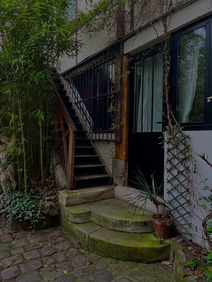 an old house with stone steps leading up to the front door