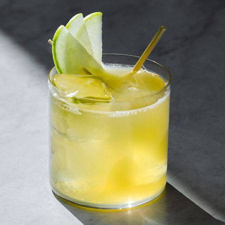 a close up of a drink in a glass with a lime slice on the rim