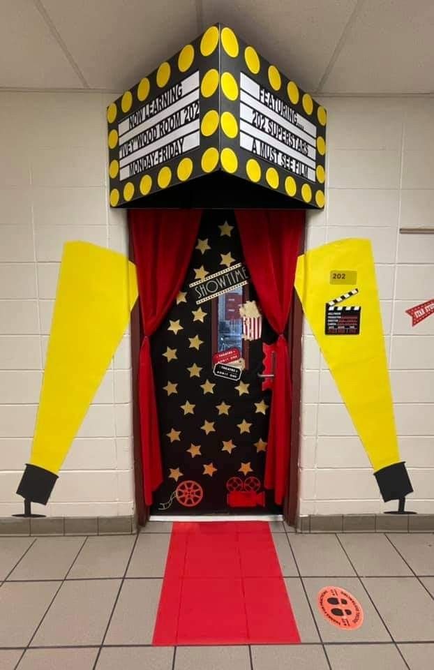 an entrance to a movie theater with red carpet and yellow drapes on the door