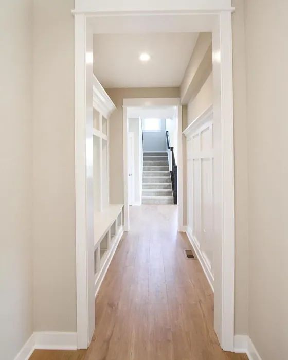 an empty hallway with wooden floors and white walls, leading to the upper level bedroom